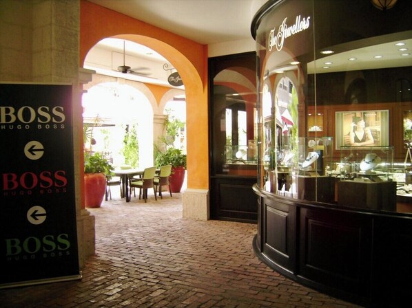 Stroll through the beautifully lined corridor, featuring a jewelry store and directional signage.