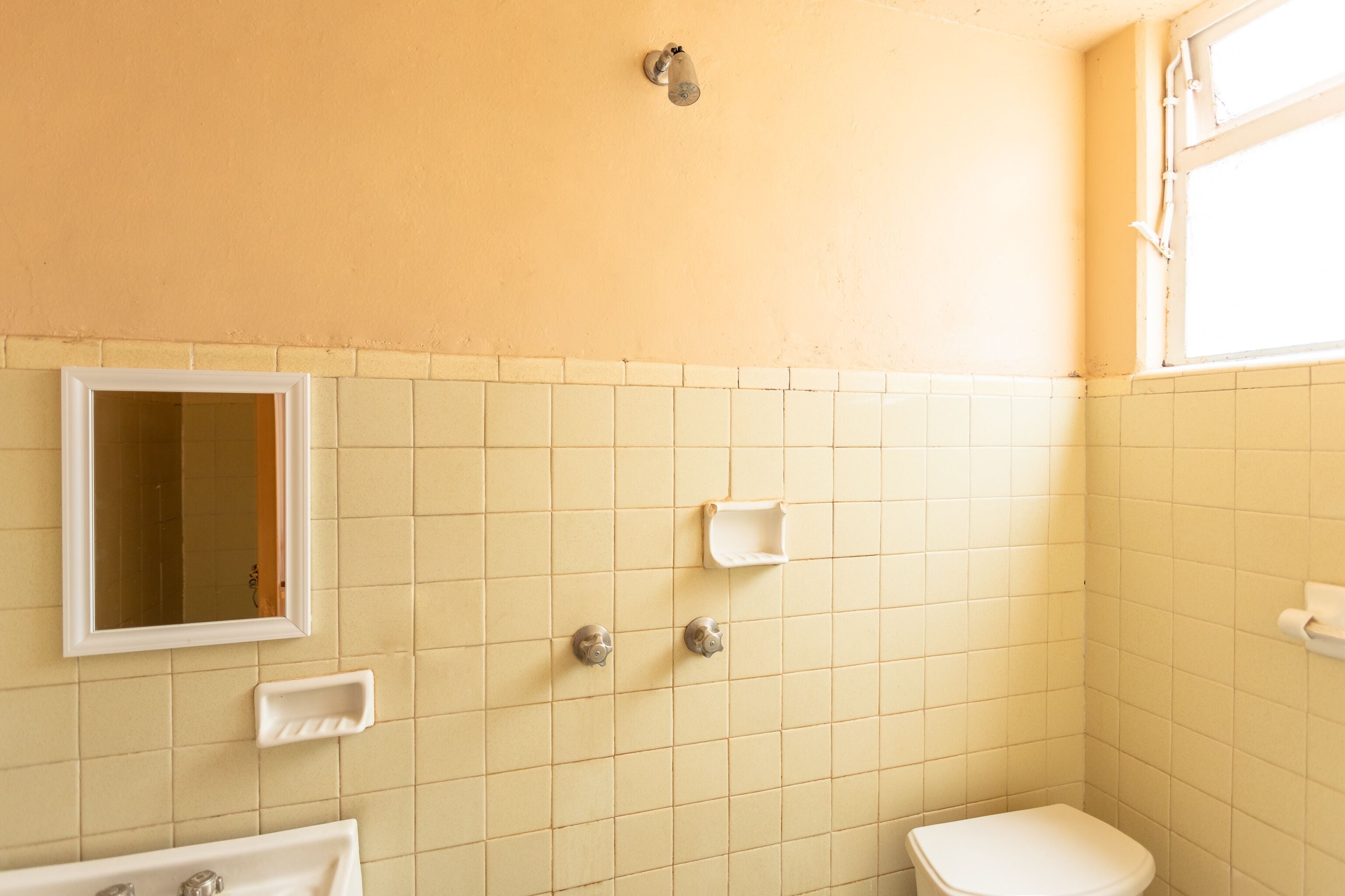 A bathroom with a sink, toilet, and mirror.