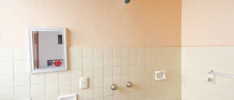 Un baño con inodoro, lavabo, espejo y paredes de azulejos.