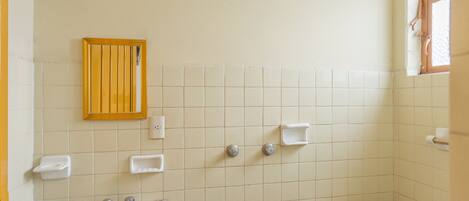 A bathroom with a sink, toilet, and a showerhead.