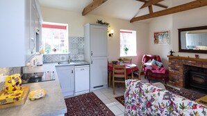 A compact kitchen with a refrigerator, sink, and a dining area with a table and chairs.