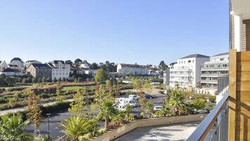 A residential area with a parking lot, palm trees, and buildings.