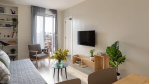 A modern living room with a sofa, a chair, a TV, and a bookshelf. - Casa Cosi - Sants Barcelona (Barcelona)
