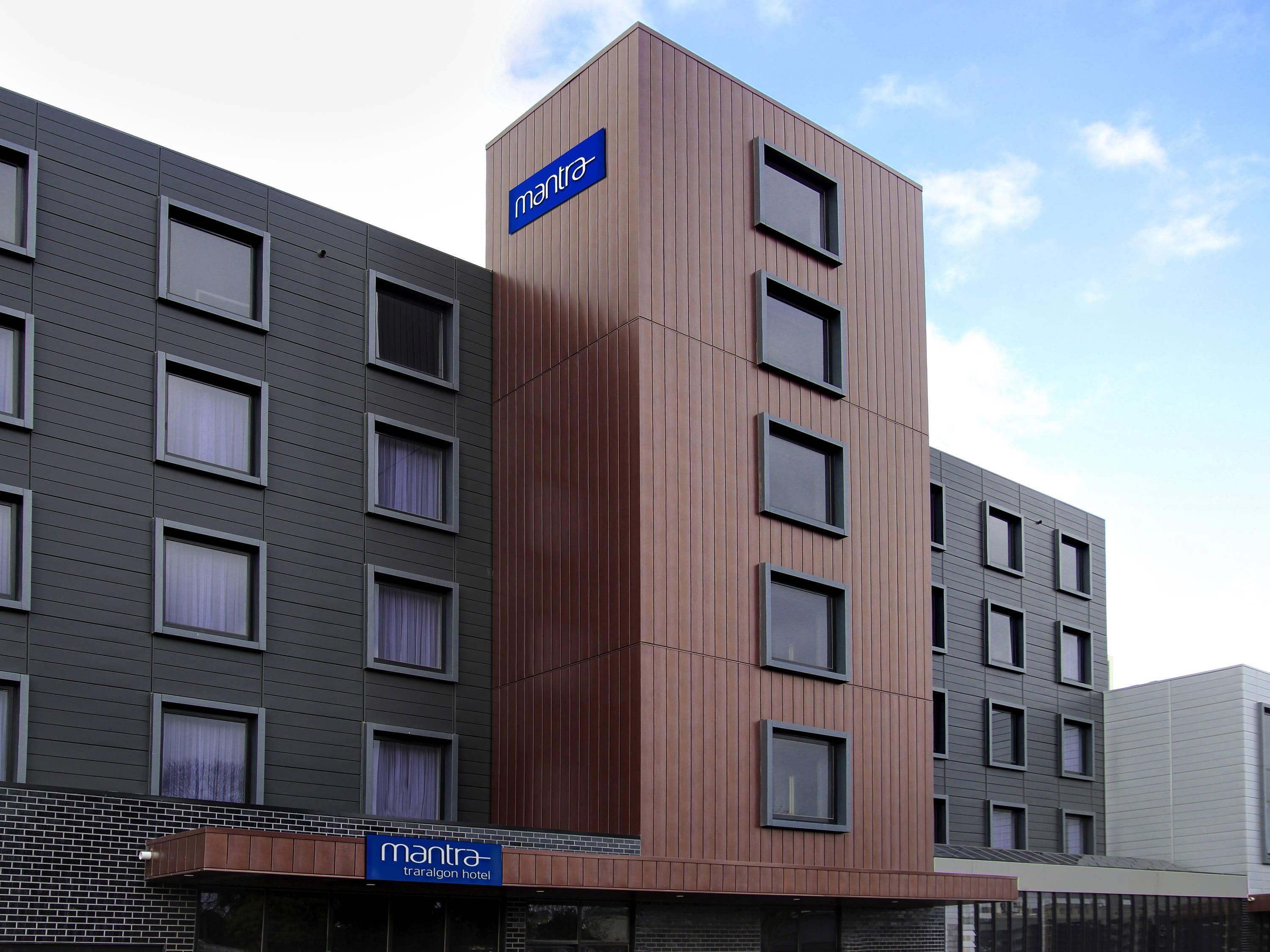 A modern hotel building with a sign reading 'mantra tralgon hotel.'