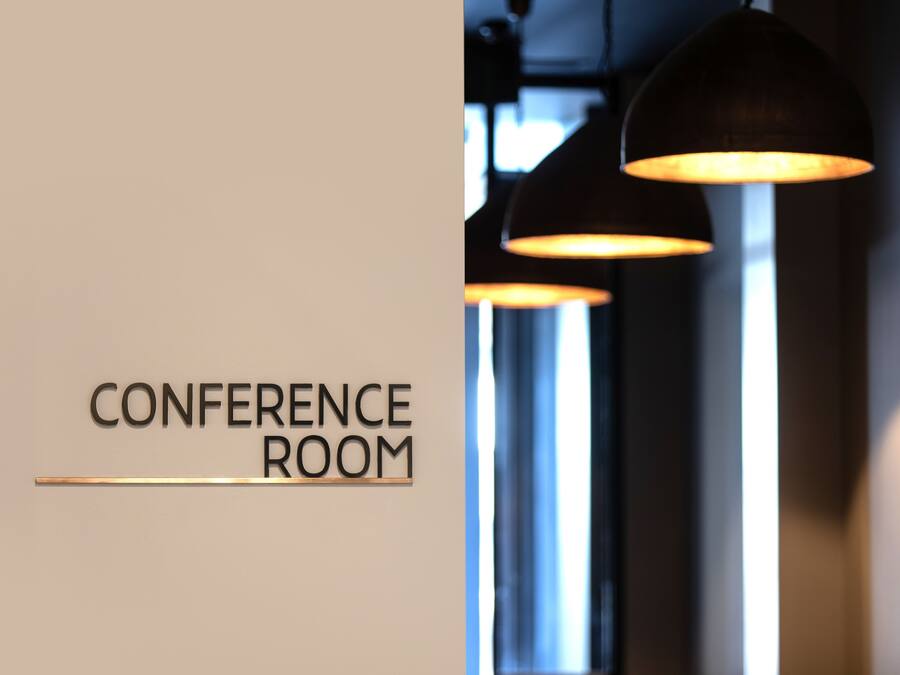 Señal que indica una sala de conferencias con iluminación colgante.