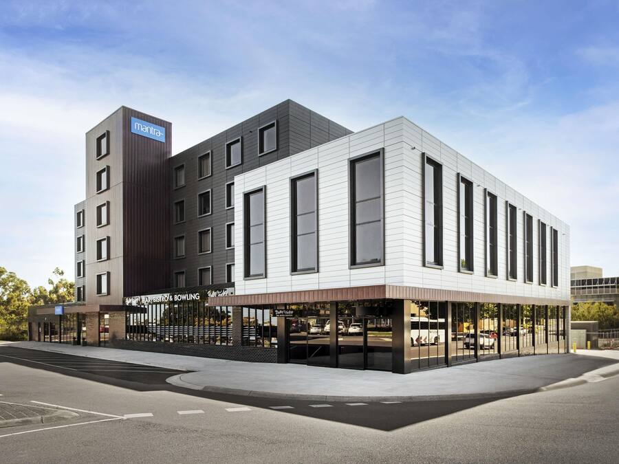 A modern building with a restaurant, bar, and bowling alley on the ground floor.