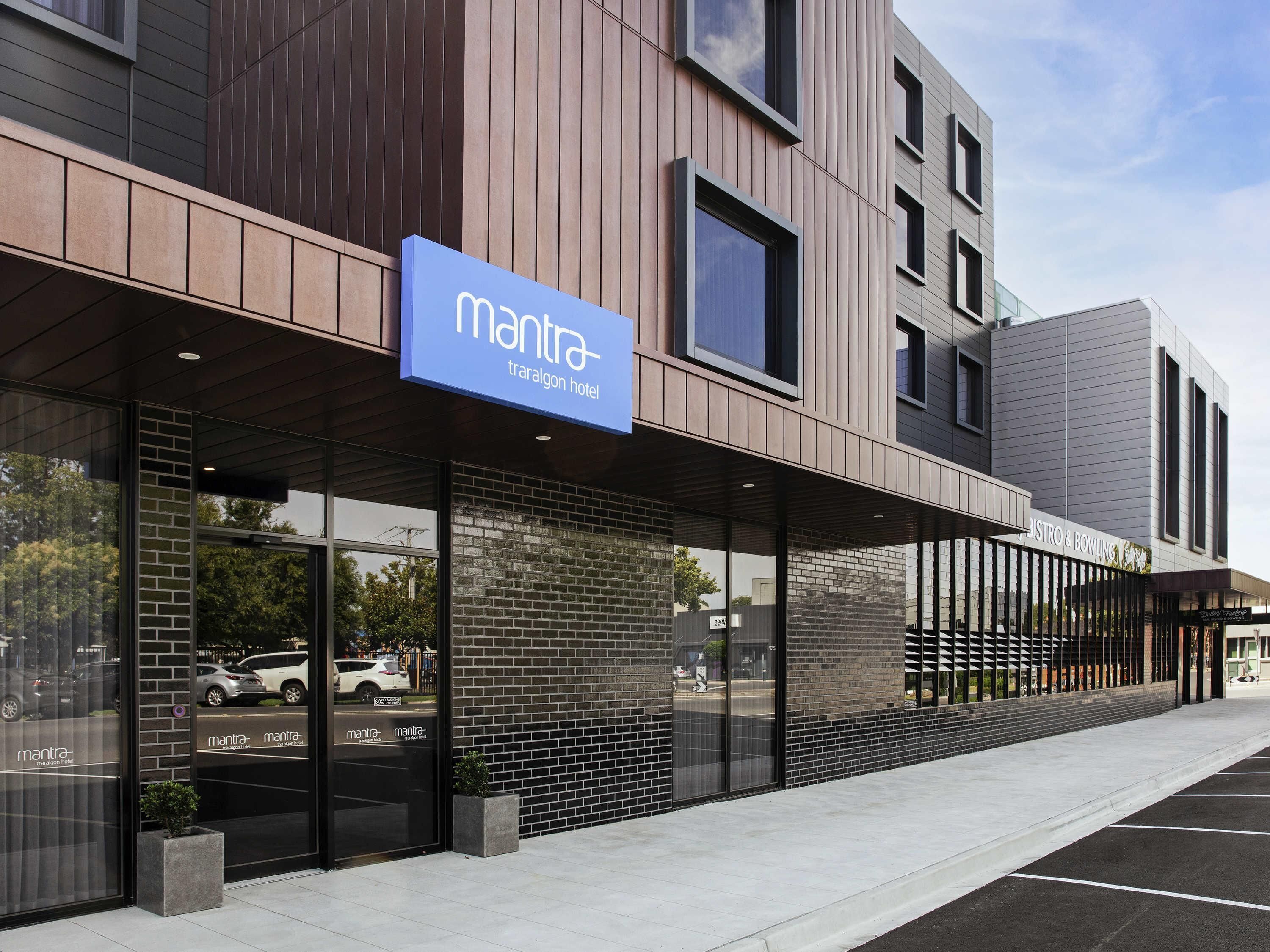 Un bâtiment moderne avec une enseigne indiquant « Mantra Tralgon Hotel » et une autre indiquant « JISTRO & BOWLING ».
