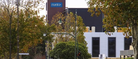A street with parked cars, a building with a sign reading 'mantra,' and a street sign for 'POST OFFICE PL.'