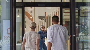 A hotel entrance with a modern design, featuring a glass door, a reception desk, and a visible air conditioning unit. - Aparthotel Adagio Access Brussels Delta (Brussels)