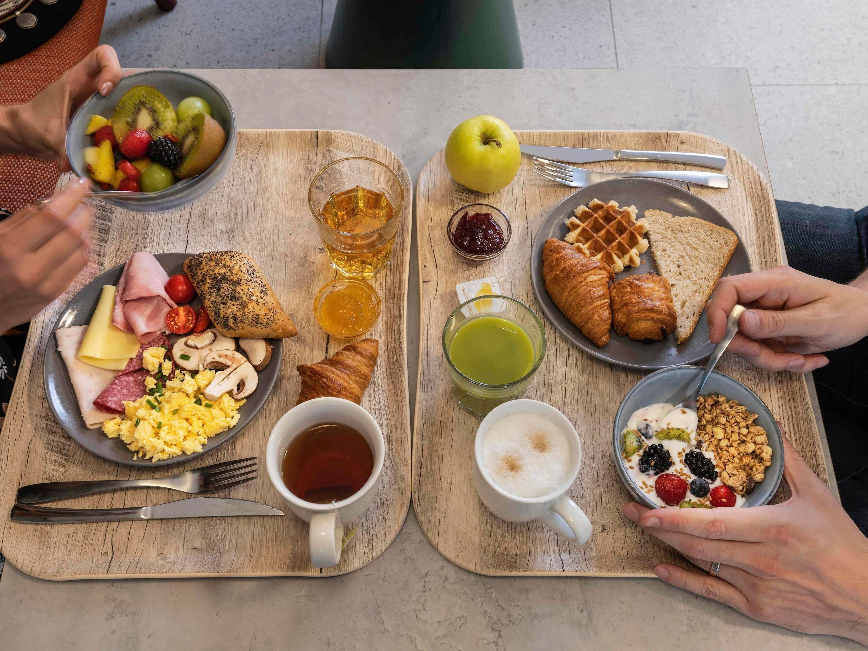 A breakfast setting with plates of food, drinks, and utensils.