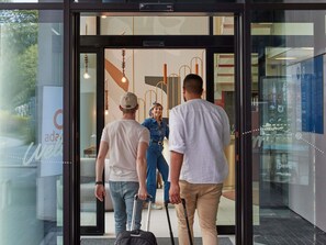 A modern hotel entrance with glass doors, a reception desk, and a visible sign for the brand 'adagio.' - Aparthotel Adagio Access Brussels Delta (Brussels)