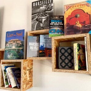Una colección de libros en estanterías de madera contra una pared.