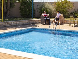 Una piscina al aire libre, tumbonas