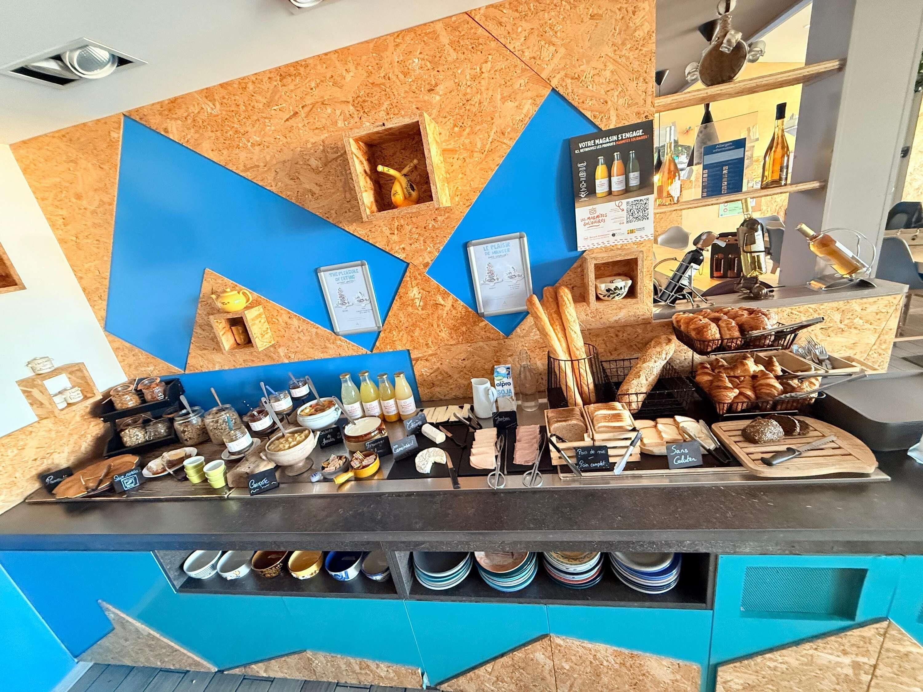 Un comptoir où sont exposés divers produits alimentaires, des condiments et une machine à café.