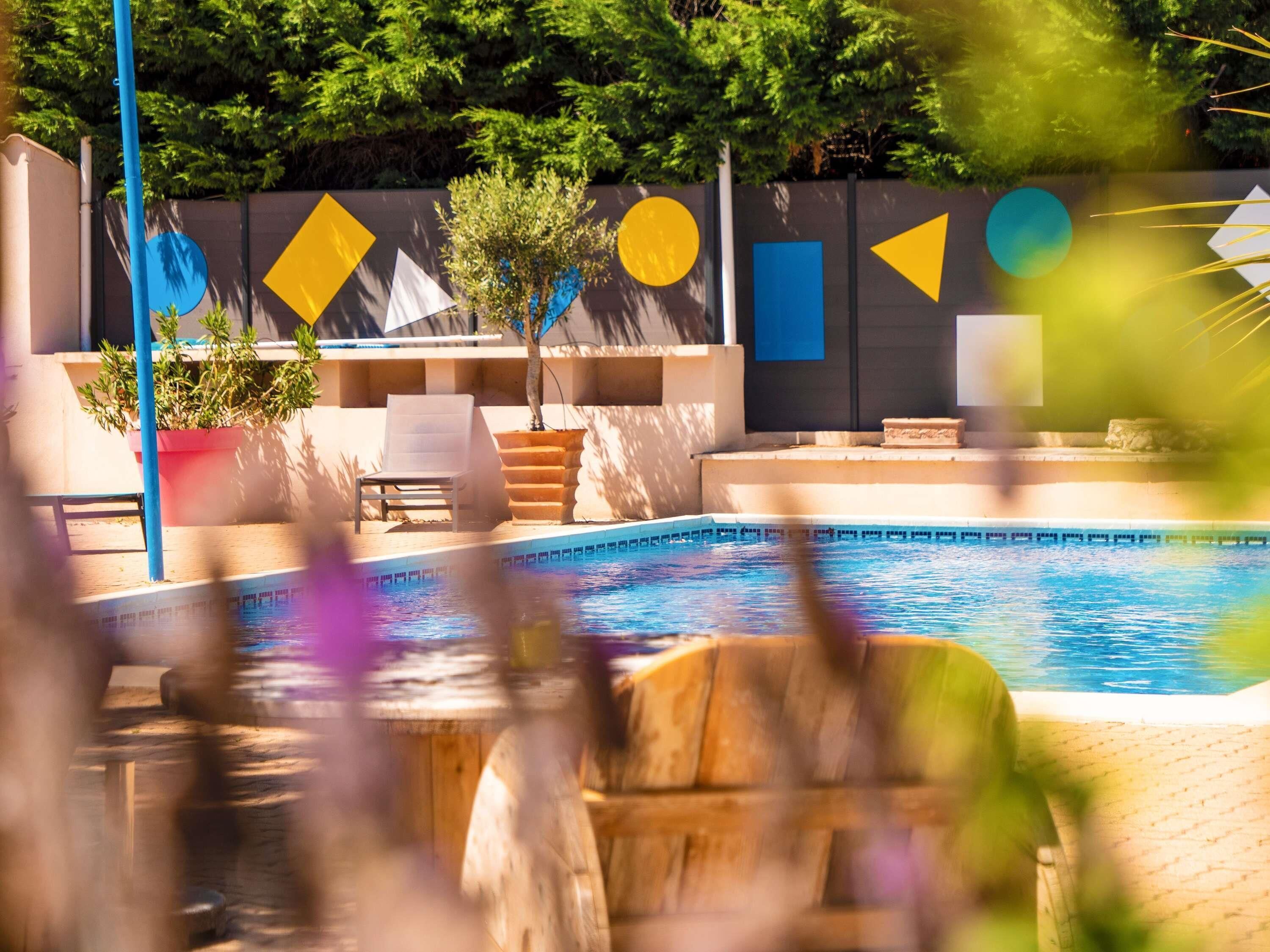 Una piscina al aire libre, sillones reclinables de piscina