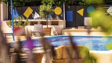 Una piscina al aire libre, sillones reclinables de piscina