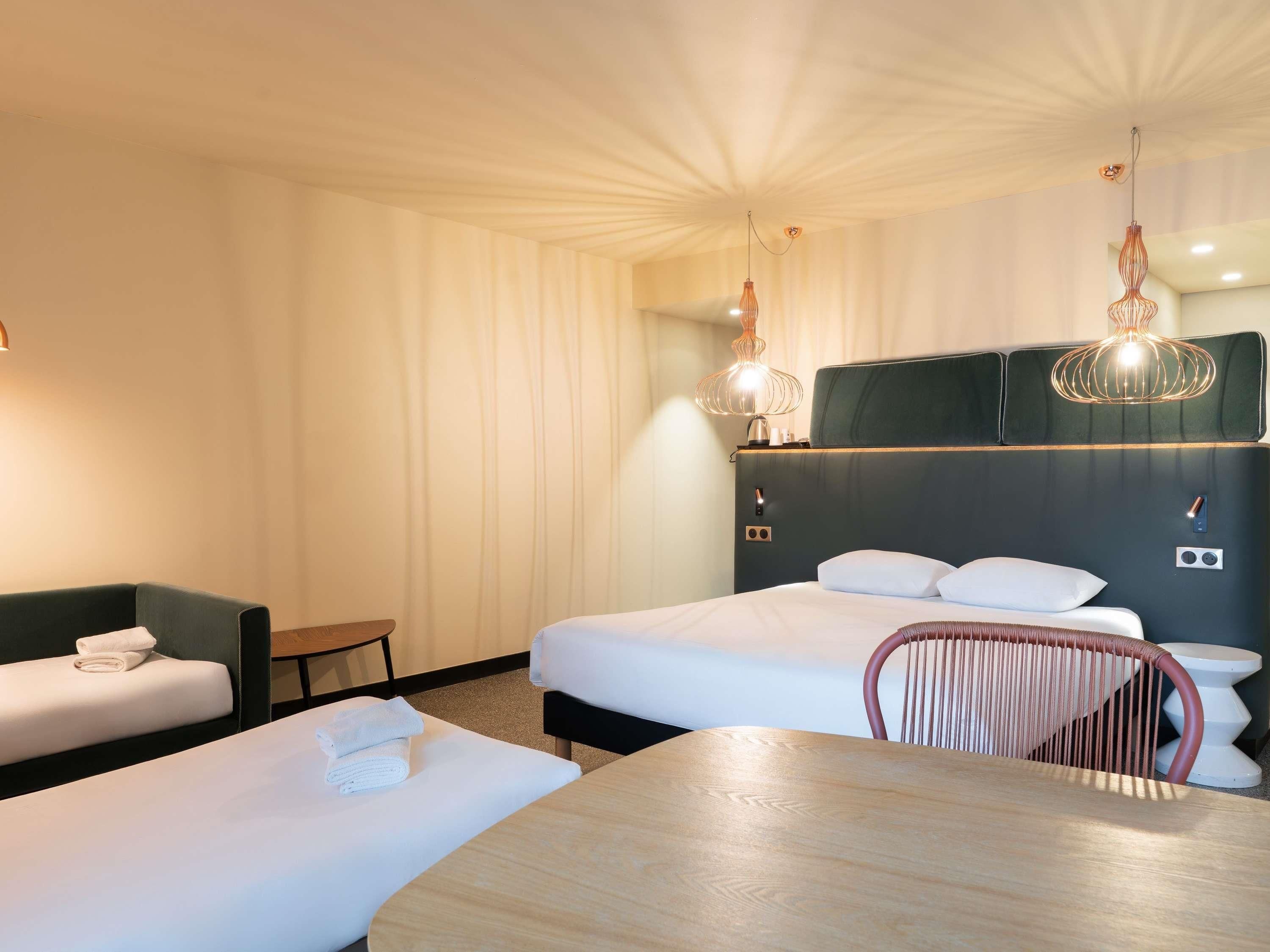Una habitación de hotel con cama, zona de estar y mesa de comedor.