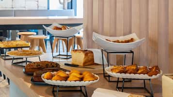 Un tavolo da buffet con diversi prodotti da forno e pasticceria.