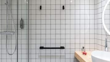 A modern bathroom with a shower, a sink, and a mirror.