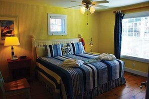 A bedroom with a bed, a nightstand, a lamp, a ceiling fan, a window with curtains, and a wall-mounted shelf. - 3 Bedroom, Luxury Cottage, Branson, Missouri 1973946 (Branson)