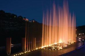 A nighttime view of a fountain with multiple water jets illuminated by lights, set against a dark sky. - 3 Bedroom, Luxury Cottage, Branson, Missouri 1973946 (Branson)