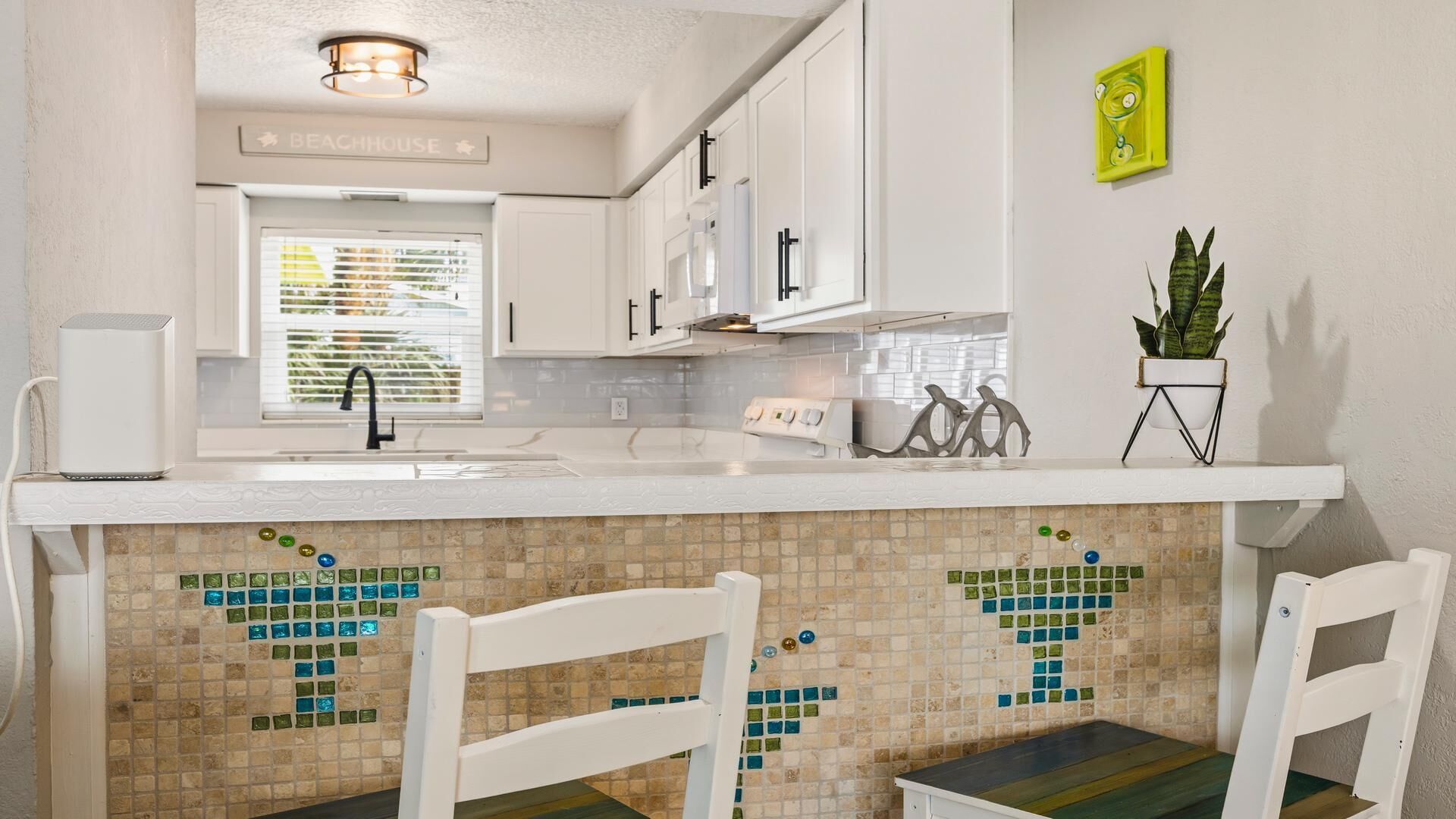 A kitchen with white cabinets, a tiled backsplash, and a window with blinds.
