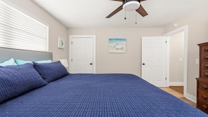 A bedroom with a bed, a ceiling fan, two doors, and a dresser. - Beachy Townhome ~ Pet Friendly ~ Steps to the Beach!!! (Saint Augustine)