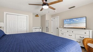A bedroom with a bed, a ceiling fan, a dresser, a television, and a door. - Beachy Townhome ~ Pet Friendly ~ Steps to the Beach!!! (Saint Augustine)
