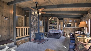 A cozy cabin interior with a stone fireplace, a leather sofa, and a wooden dining table. - Cabin by Rio Grande - 19 Mi to Wolf Creek! (South Fork)