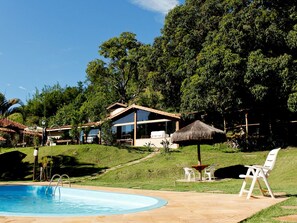 Una piscina al aire libre, tumbonas