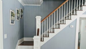 A staircase with white railings and wooden steps leading to a landing. - This Suite Old House (Cocoa)