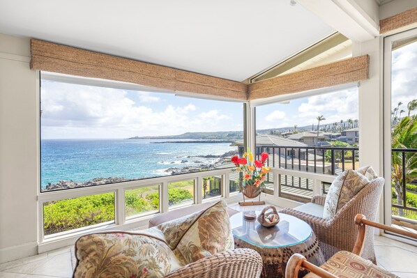 A balcony with a view of the ocean and a dining area with wicker furniture and a glass table. - Kapalua Bay Villa 34B3 Corner Ocean View Villa (Lahaina)