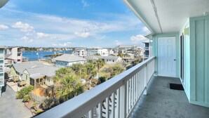 Un balcon donnant sur un port de plaisance et des immeubles d’habitation.