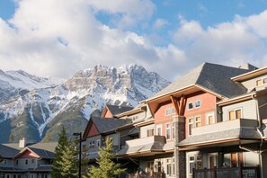 Un rifugio alpino con diversi edifici, ognuno dotato di balconi e vista sulle cime innevate.