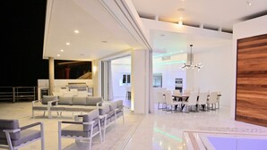 A modern interior with a seating area, dining space, and a kitchen.