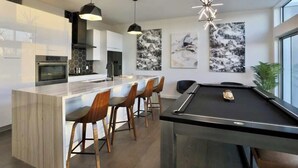 Een moderne keuken met een centraal eiland, een bar en zitplaatsen.