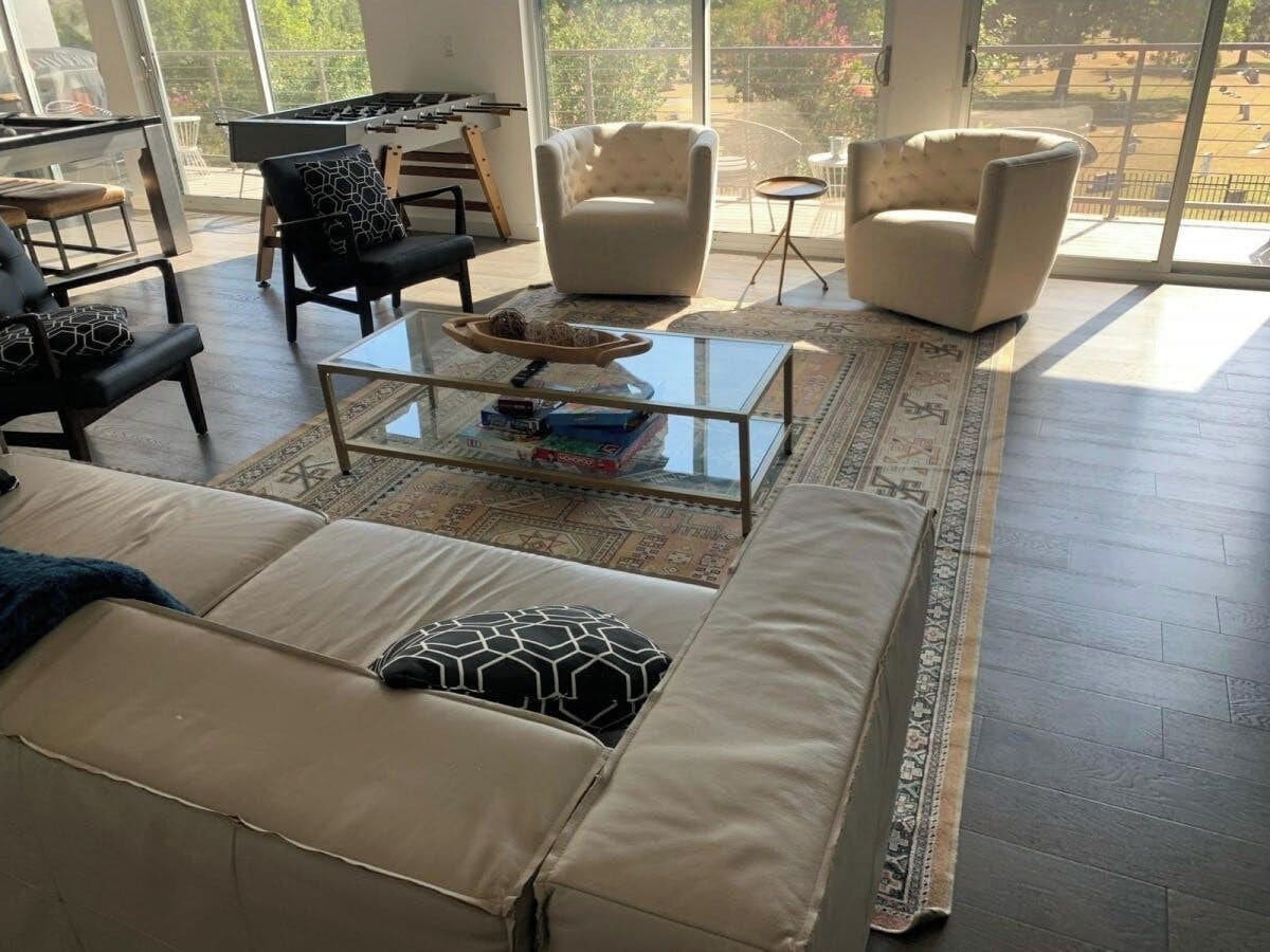 A spacious living area with a sofa, armchairs, a coffee table, and a view of the outdoors.
