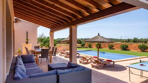 A covered outdoor area with a pool, lounge chairs, and a sofa. - Beautiful Country House "Sa Xorca" with Pool, Air Conditioning, and Wi-Fi (Santanyí)