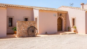 A building with a stone wall, a wooden door, and a wheel. - Beautiful Country House "Sa Xorca" with Pool, Air Conditioning, and Wi-Fi (Santanyí)