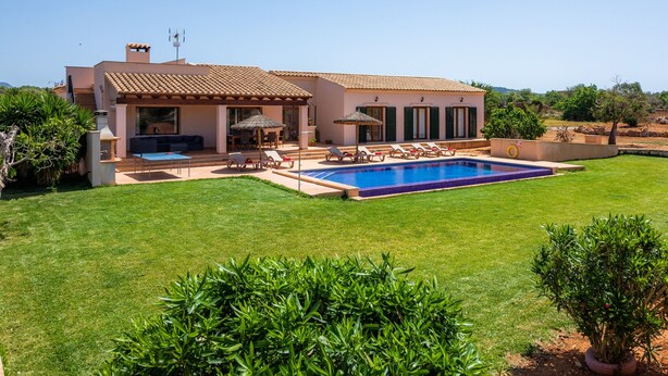 A house with a swimming pool, outdoor seating, and a well-maintained lawn. - Beautiful Country House "Sa Xorca" with Pool, Air Conditioning, and Wi-Fi (Santanyí)