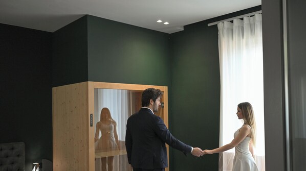 Una habitación con un ventanal grande, un armario de madera y una cama.