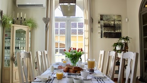 A dining area with a table set for breakfast, including bread, eggs, and juice. - Le Clos Vitis - Chambres d'hôtes et gite (Violes)