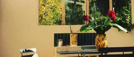 A dining area with a table, chairs, and a vase with flowers.