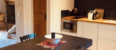 Une cuisine moderne avec une porte en bois, un four à micro-ondes et un évier.
