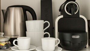 Une cuisine équipée d’une machine à café, d’une bouilloire et d’un moulin à café.