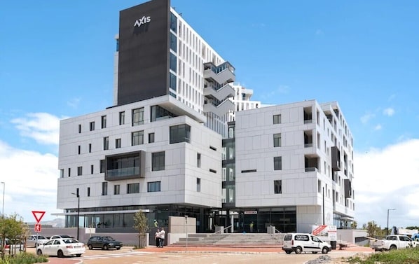A modern building with a prominent black and white facade, multiple balconies, and a clear sky. - Axis (Cape Town)