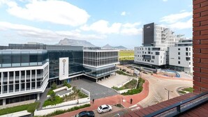 A modern building with a glass facade and a Discovery logo, surrounded by other contemporary structures and a clear sky. - Matrix (Cape Town)