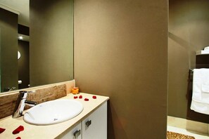A bathroom with a white sink, a mirror, and a towel rack.