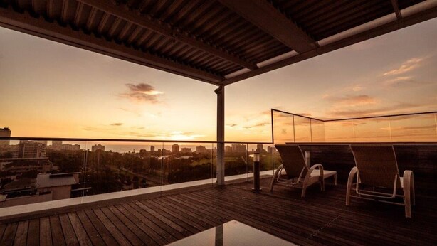 A rooftop terrace with a wooden deck and two lounge chairs. - The Legacy II (Cape Town)