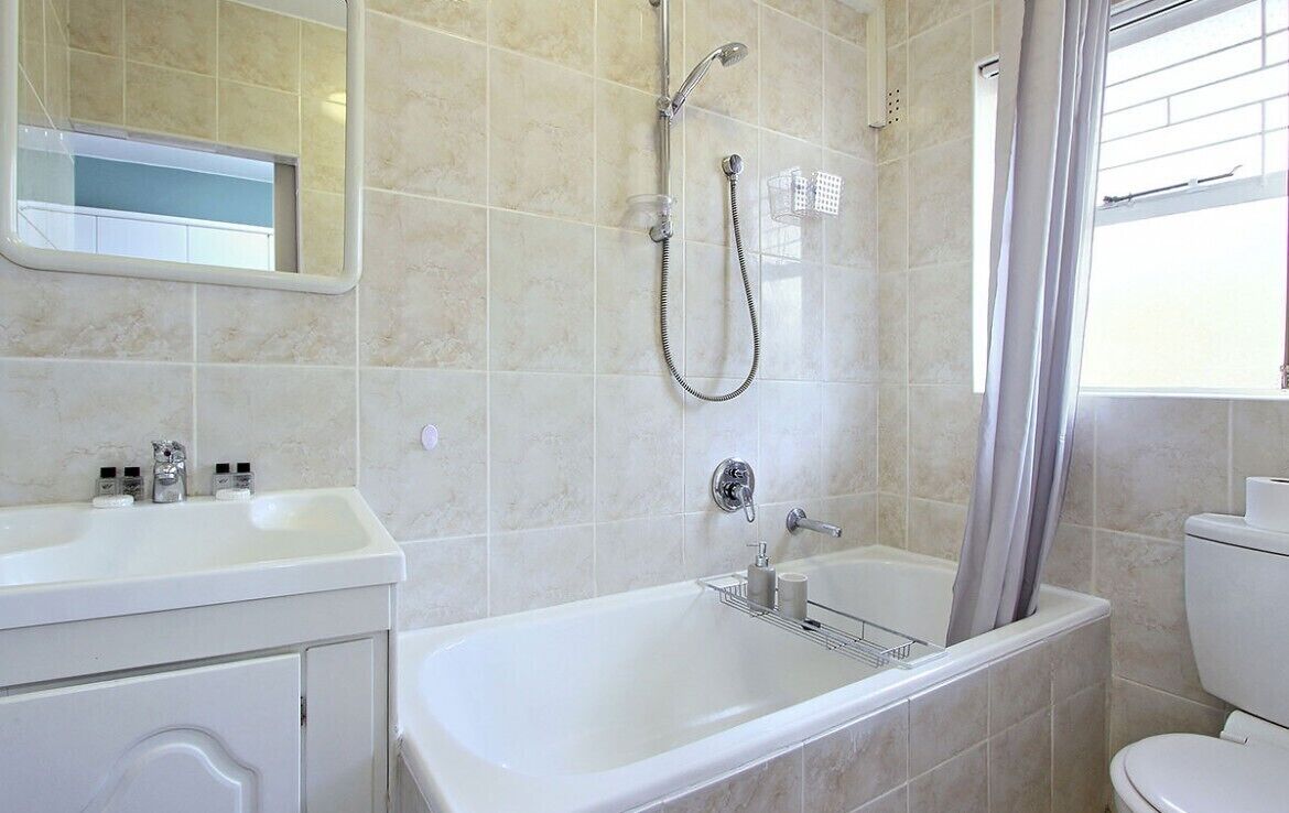 A bathroom with a bathtub, a shower, a sink, and a toilet.